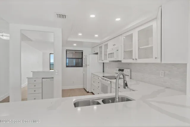 a kitchen with white cabinets and white appliances
