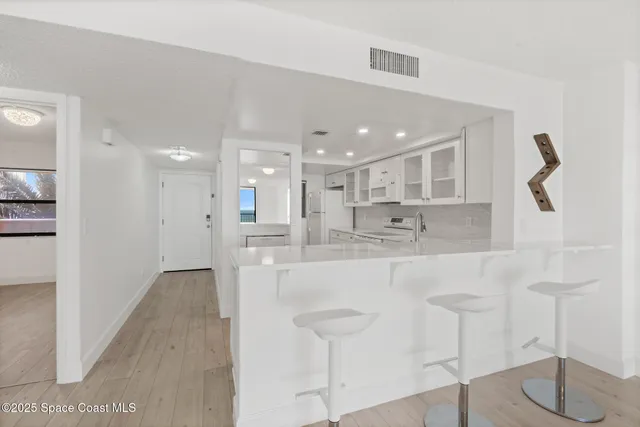 a large kitchen with kitchen island a sink table and chairs
