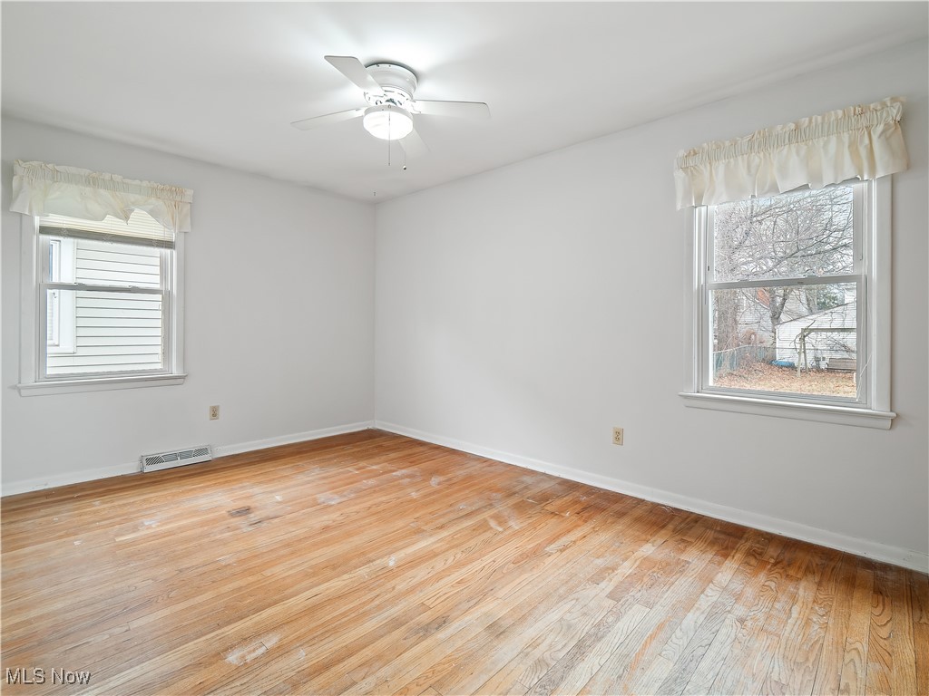23812 Knickerbocker Road Bay Village, OH 44140 - Photo 13 of 31 Empty room featuring ceiling fan, a wealth of natural light, and light hardwood / wood-style floors