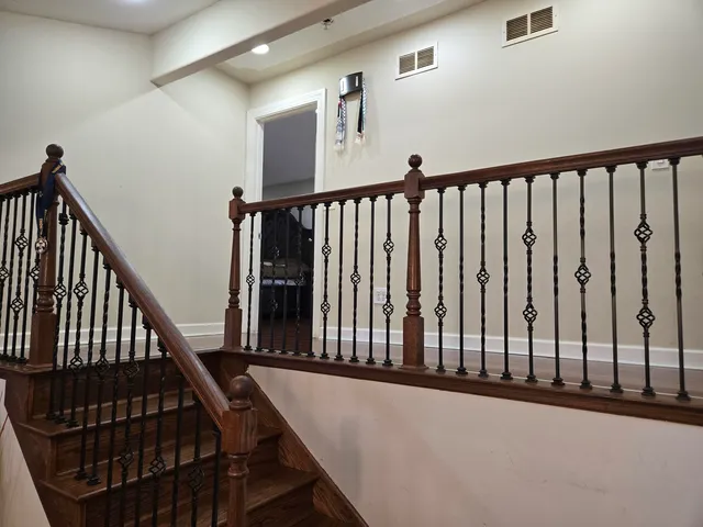 a view of staircase with lots of frames on wall