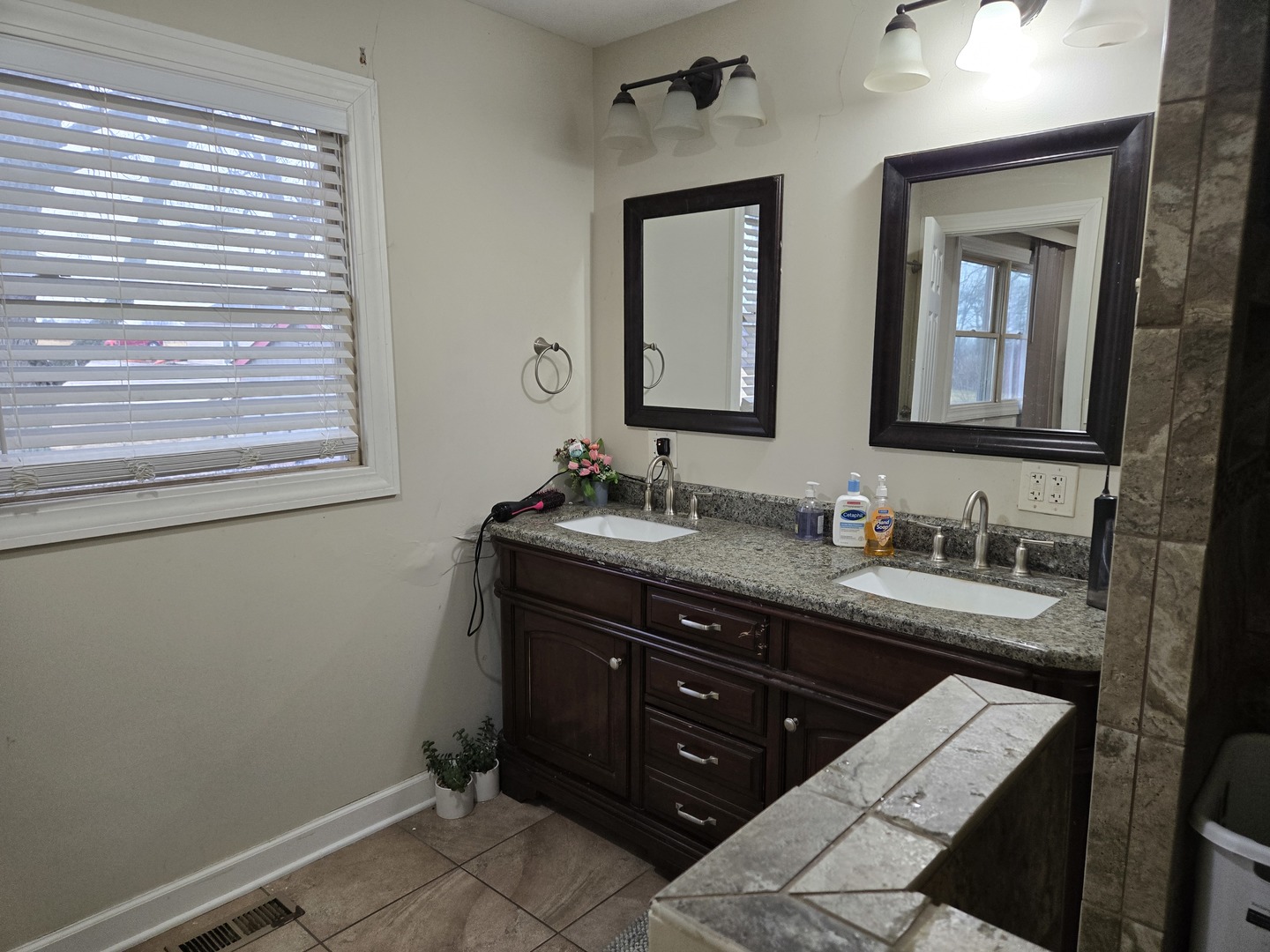 3303 East Exchange Street Crete, IL 60417 - Photo 17 of 38 a bathroom with a granite countertop sink toilet a mirror and a window
