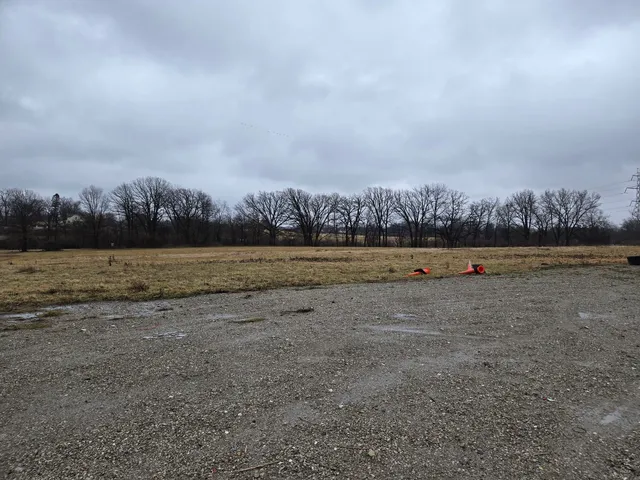 a view of a field with ocean in background