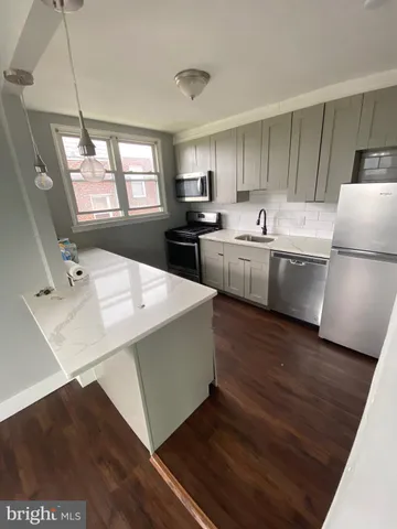 a kitchen with a sink a stove a refrigerator and white cabinets