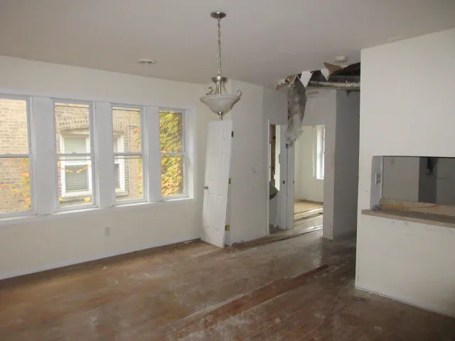 an empty room with windows and cabinet