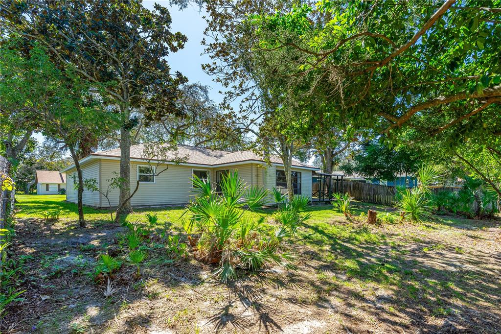 693 Reillys Road Port Orange, FL 32127 - Photo 4 of 31 a backyard of a house with lots of green space and fountain