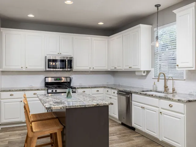 a kitchen with stainless steel appliances granite countertop a sink a stove a microwave and cabinets