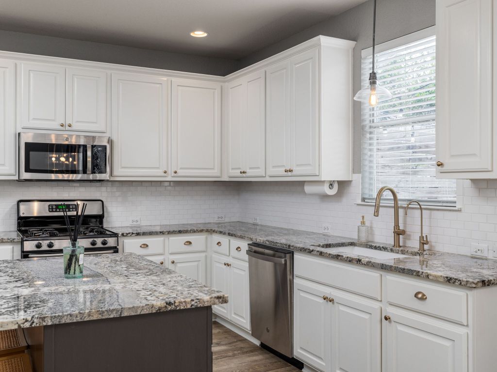 2349 Caprock Place Georgetown, TX 78626 - Photo 14 of 38 a kitchen with granite countertop white cabinets and a sink