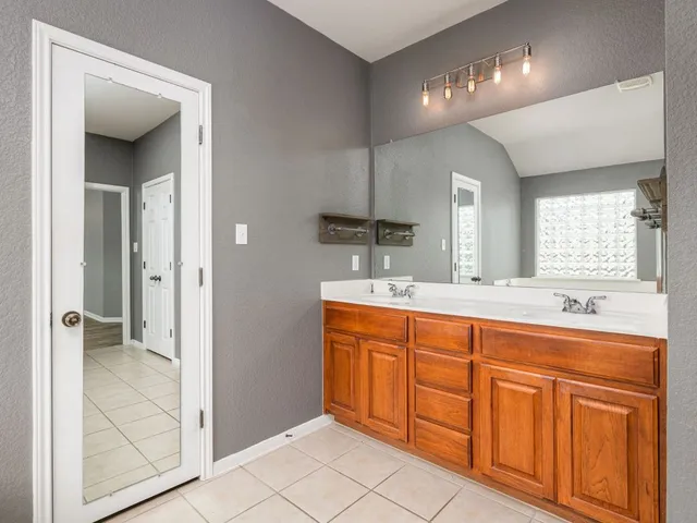 a spacious bathroom with a double vanity sink a mirror and a shower