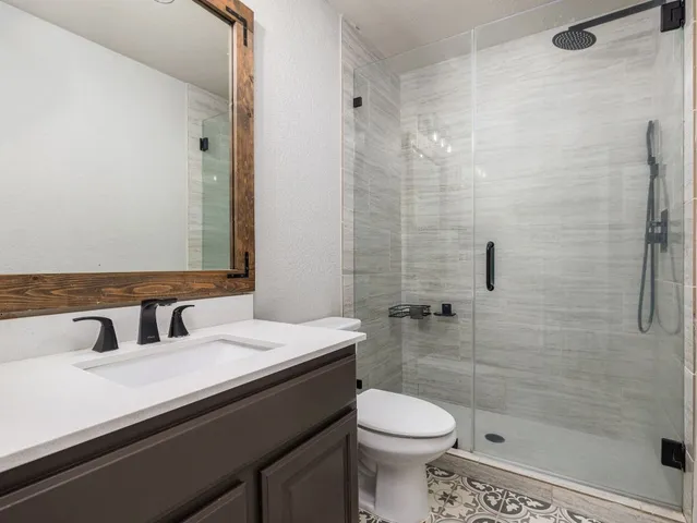 a bathroom with a sink a toilet and shower