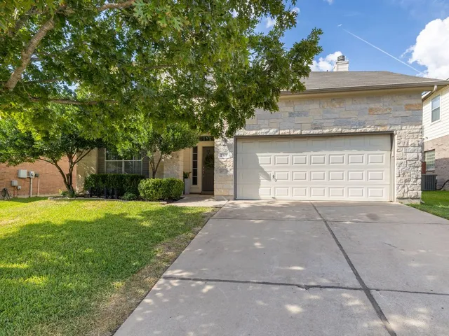 a front view of a house with a yard and a garage
