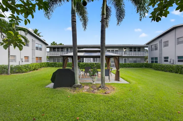 a view of a house with a backyard and a tree