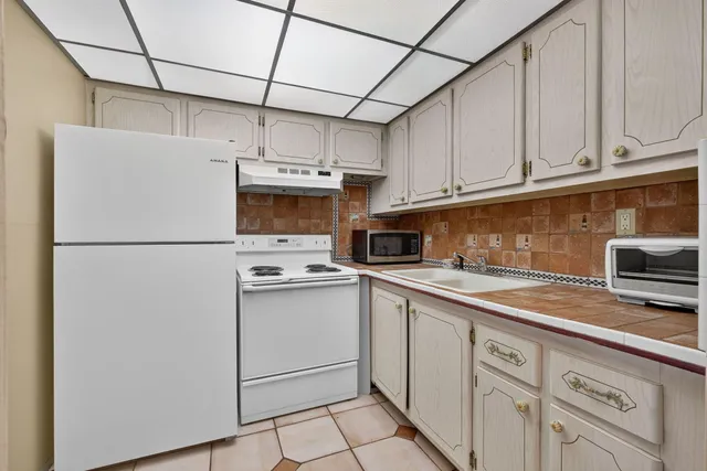 a kitchen with stainless steel appliances granite countertop a refrigerator a stove a sink dishwasher and white cabinets
