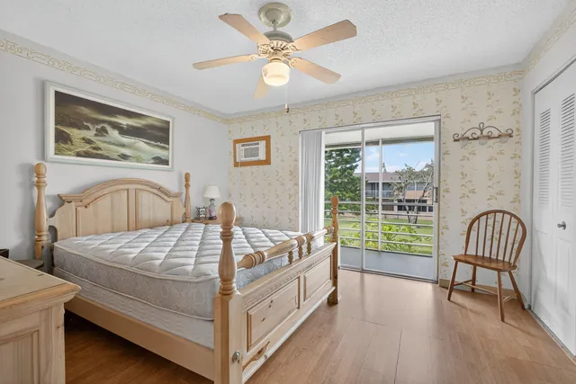 a bed sitting in a spacious bedroom next to a window