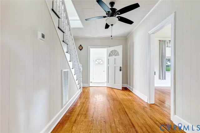 a view of a hallway with wooden floor and staircase
