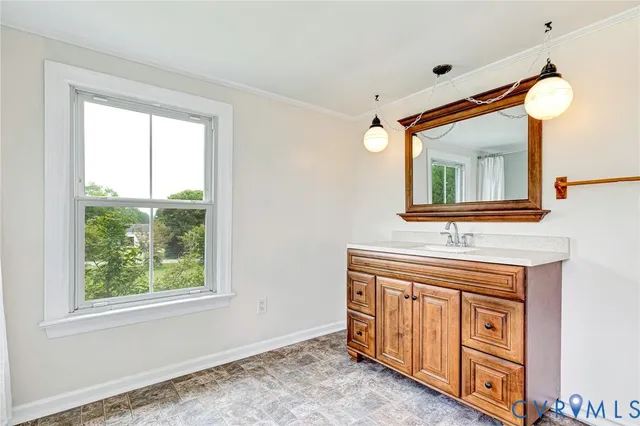 a hallway with a sink a mirror and a window