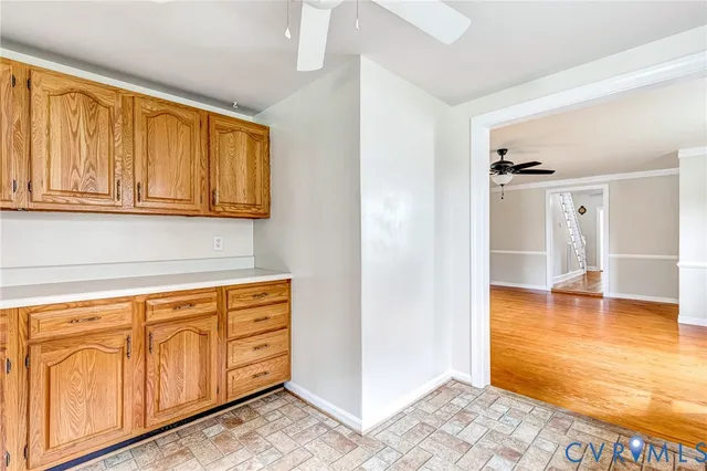 a view of walk in closet with an empty room and wooden floor