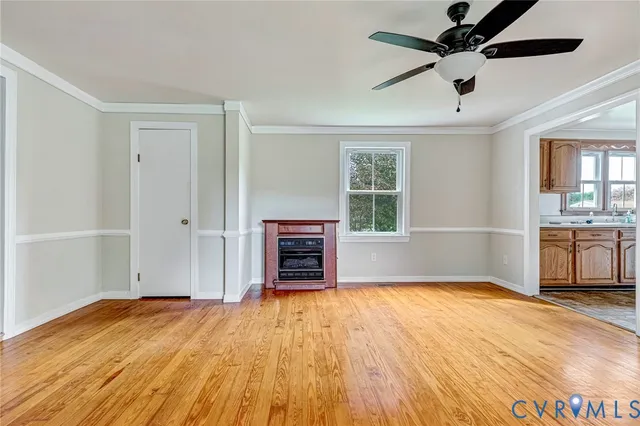 a view of empty room with a kitchen and a window