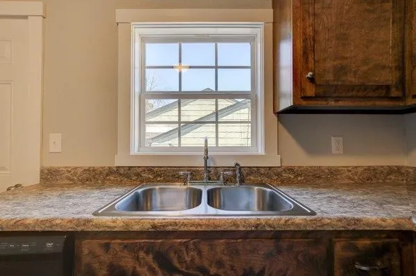 a bathroom with a granite countertop bathtub shower sink vanity and toilet