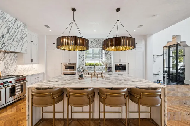 a kitchen with stainless steel appliances granite countertop a stove a sink and a refrigerator with wooden floor