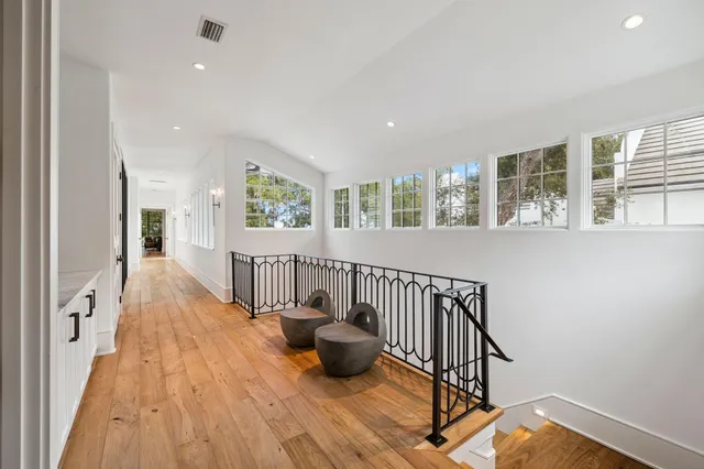 a view of a hallway with wooden floor and windows