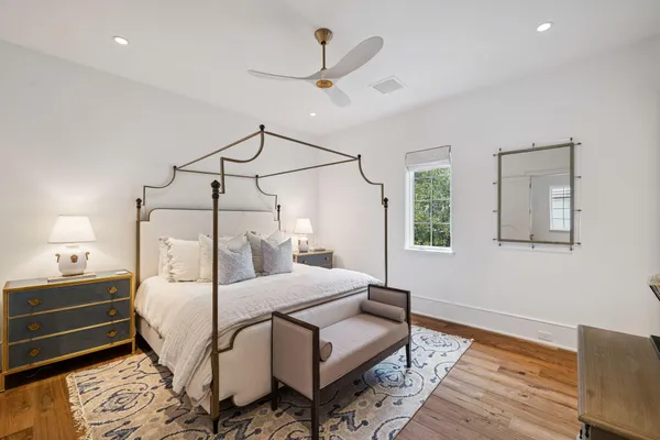 a bedroom with a bed a chandelier and dresser