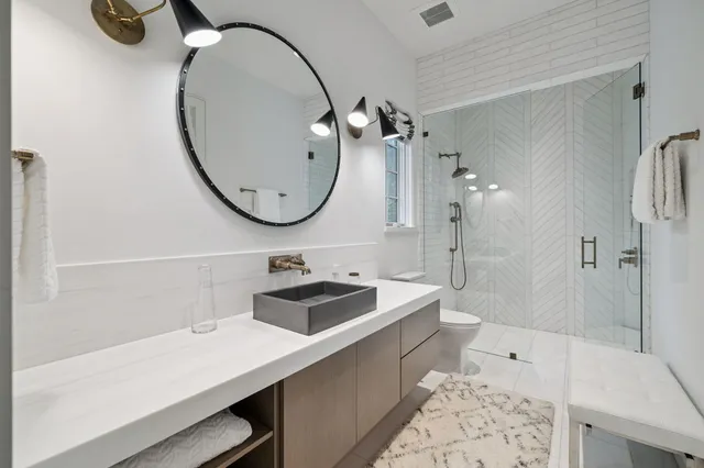 a bathroom with a sink a toilet and shower