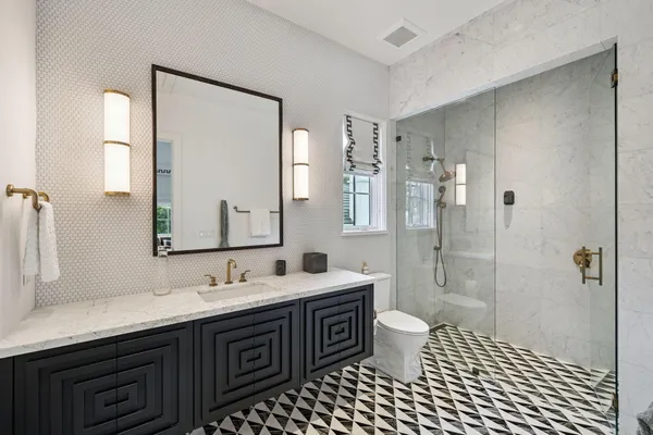 a bathroom with a double vanity sink toilet and shower