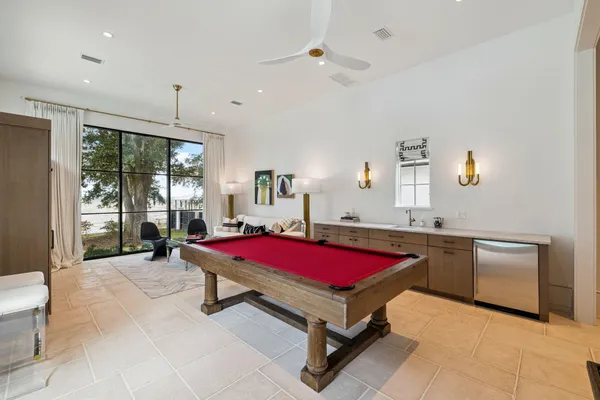 a room with pool table and windows