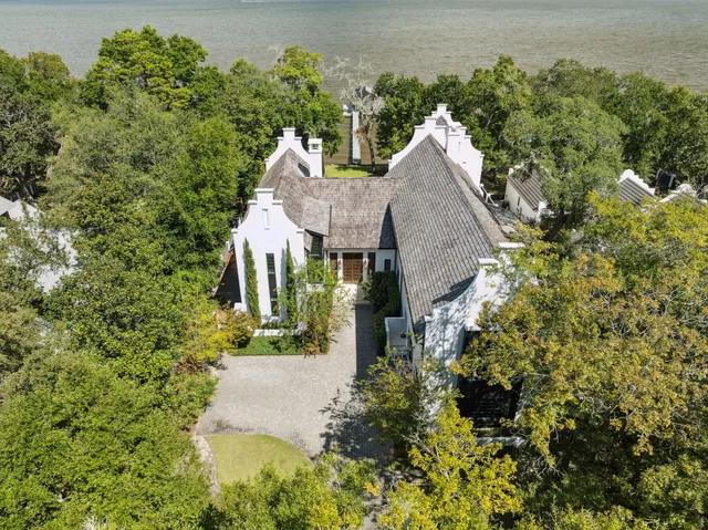 an aerial view of a house with a yard and large trees