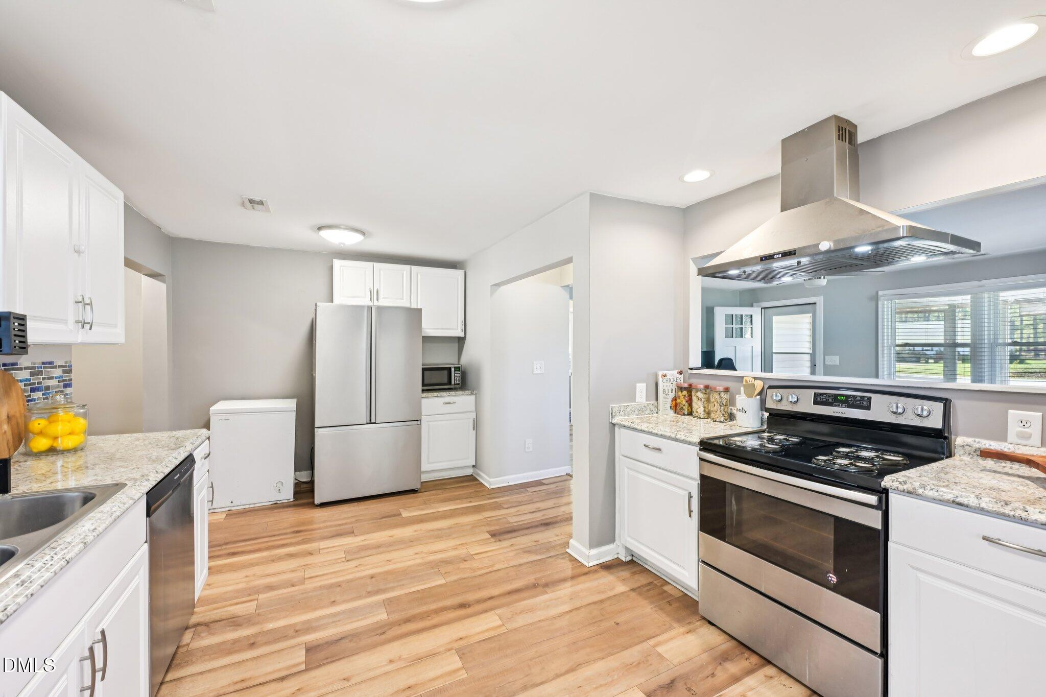 712 Fairground Road Dunn, NC 28334 - Photo 7 of 23 a kitchen with stainless steel appliances a stove a refrigerator and cabinets