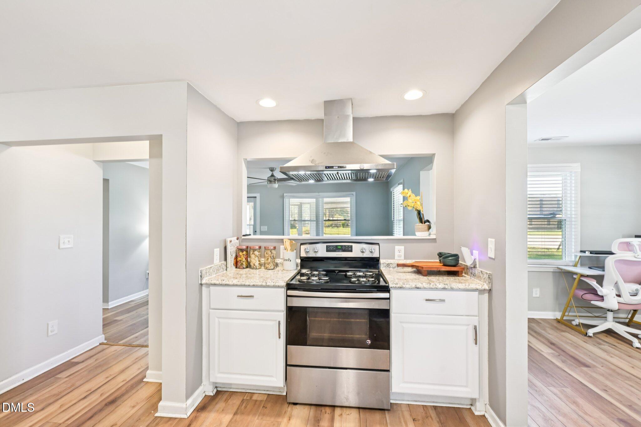 712 Fairground Road Dunn, NC 28334 - Photo 9 of 23 a kitchen with a stove and white cabinets