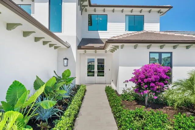 a large kitchen with a large counter top space a sink stainless steel appliances and cabinets