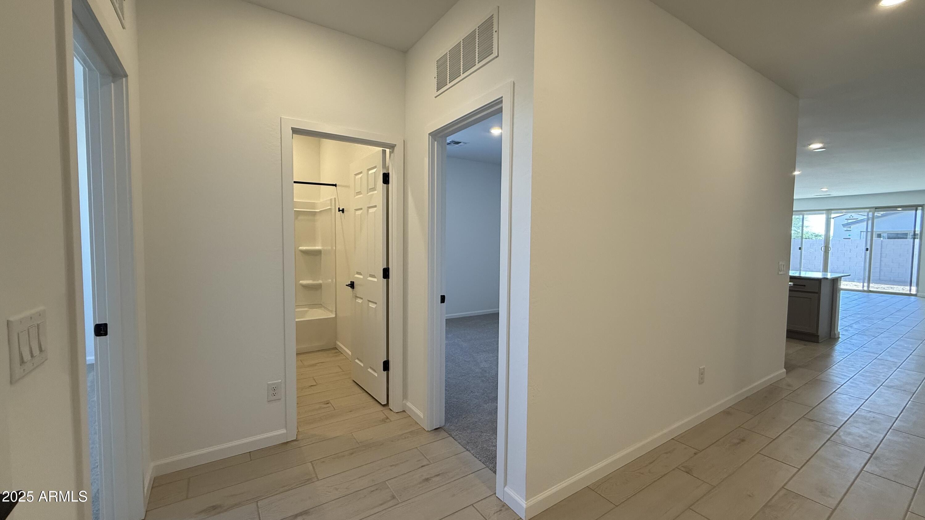 46819 West Old Timer Road Maricopa, AZ 85139 - Photo 5 of 44 a view of a hallway with wooden floor and a bathroom