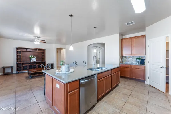 a kitchen with kitchen island a sink a counter top space and stainless steel appliances