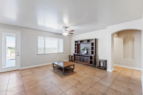 a living room with furniture a piano and a window