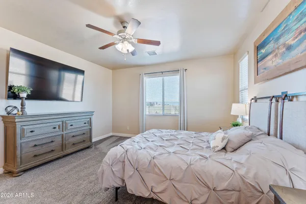 a bedroom with a large bed and a flat tv screen on dresser