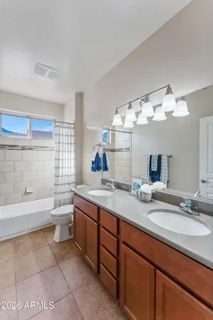 a bathroom with a granite countertop sink mirror bathtub and toilet