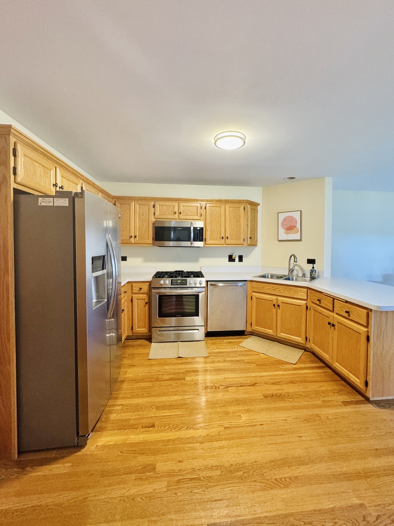 19245 Tramore Lane Mokena, IL 60448 - Photo 6 of 21 a large white kitchen with stainless steel appliances granite countertop a stove and a refrigerator