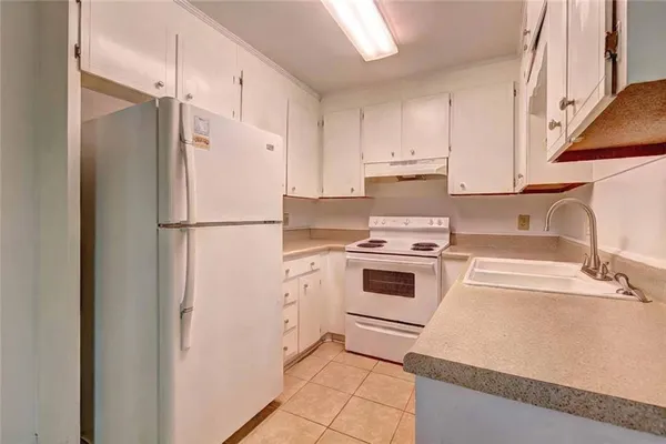 a kitchen with a refrigerator sink stove and cabinets