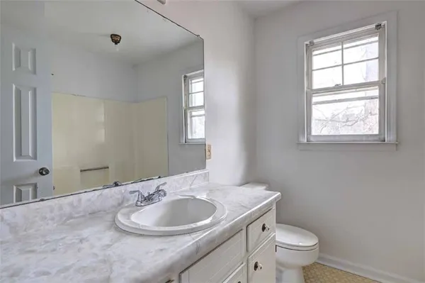 a bathroom with a toilet sink and mirror