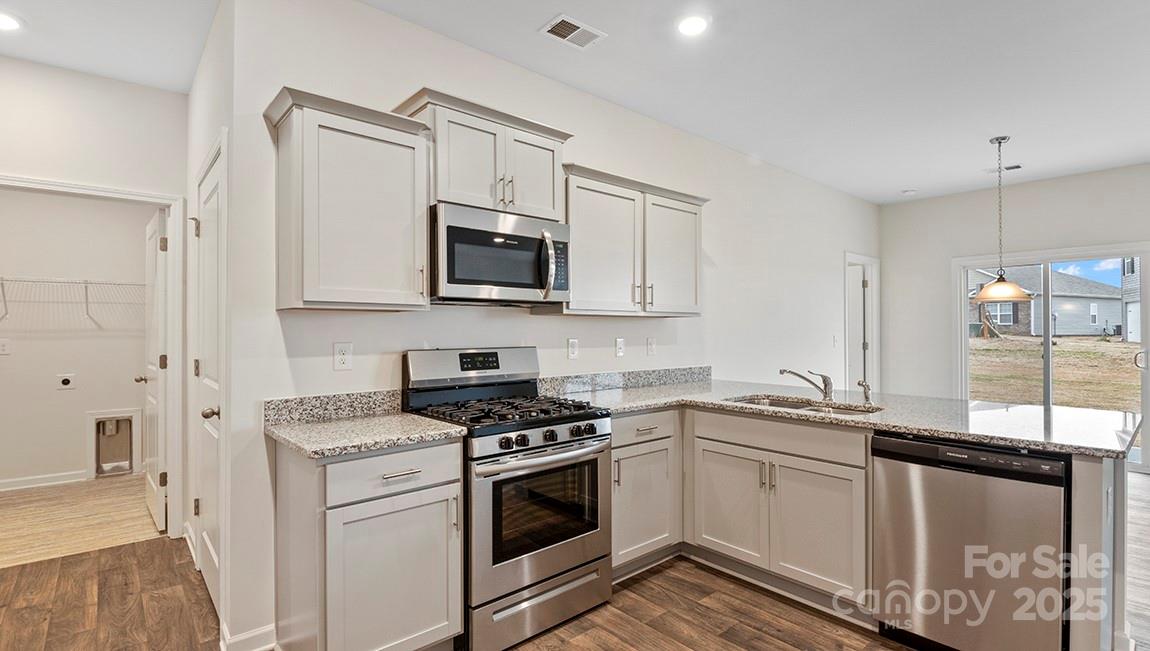 15 Shorthorn Road Fletcher, NC 28732 - Photo 6 of 34 a kitchen with granite countertop a sink a stove and microwave