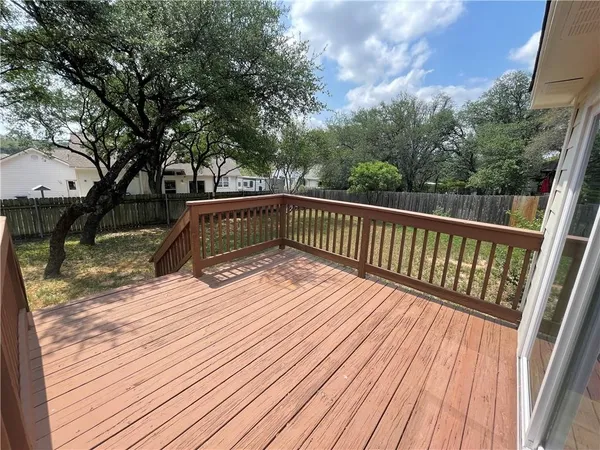 a view of a backyard with wooden fence and a large tree