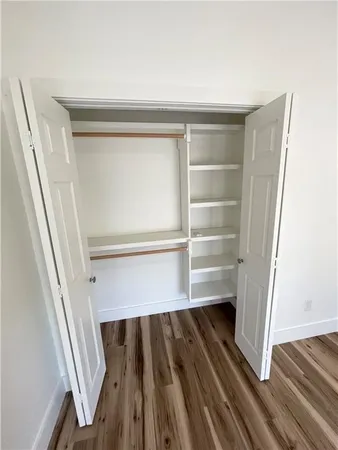 a view of walk in closet with empty racks