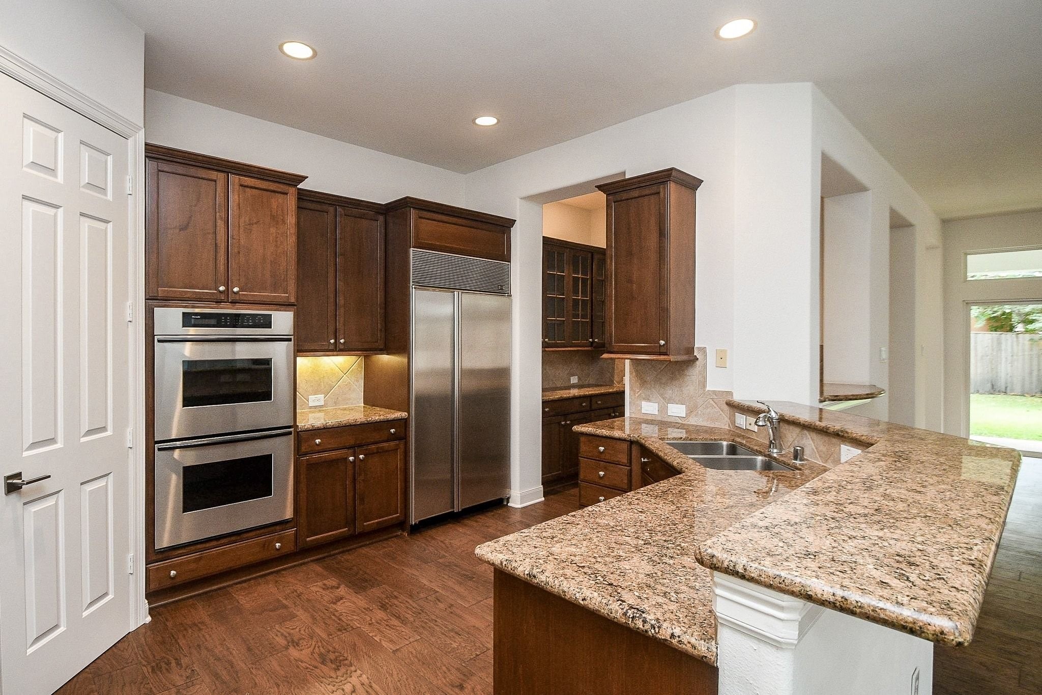 2826 Tudor Manor Houston, TX 77082 - Photo 11 of 37 This open-concept kitchen features 42-inch cabinetry, a double oven, and deep-basin sinks.