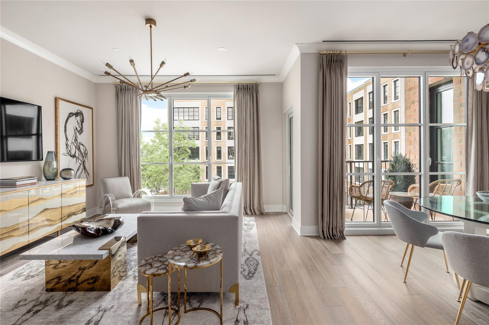Living room with an inviting chandelier, light hardwood / wood-style flooring, and ornamental molding