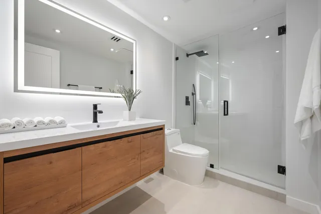 a bathroom with a sink a toilet and shower