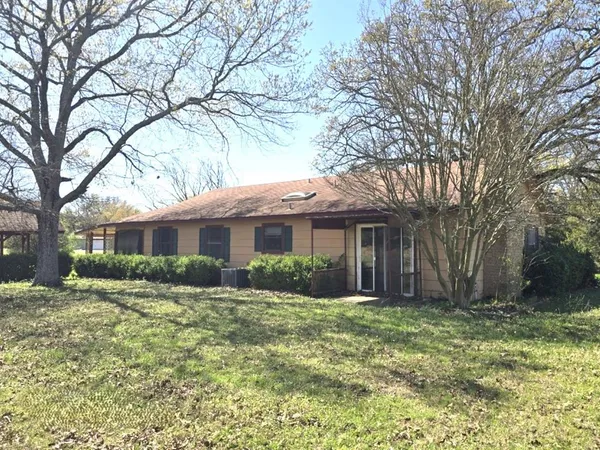 a front view of house with yard and trees