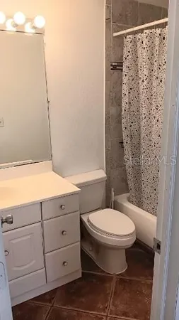 a bathroom with a granite countertop toilet and a shower