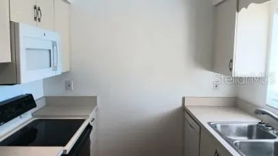 a kitchen with a sink a stove and cabinets