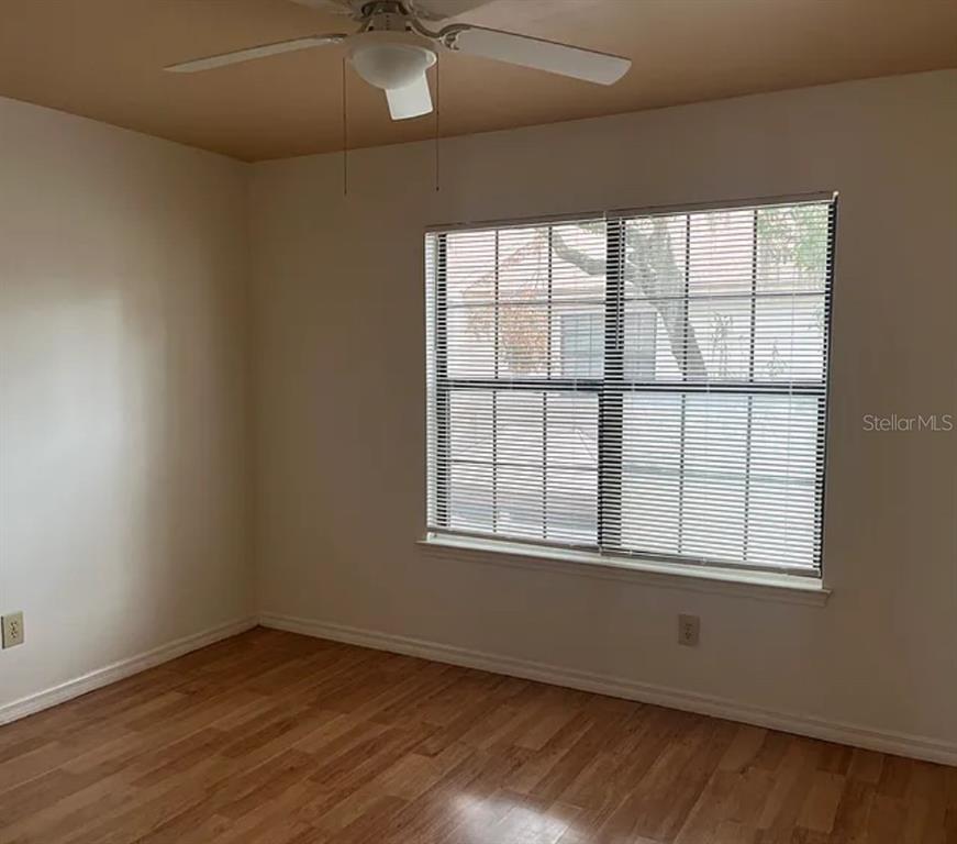 2302 South Maki Road, Unit 98 Plant City, FL 33563 - Photo 6 of 7 an empty room with wooden floor and windows
